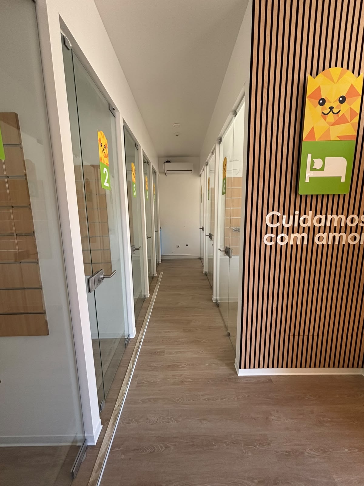 Corredor com as suites individuais de porta de vidro, numeradas